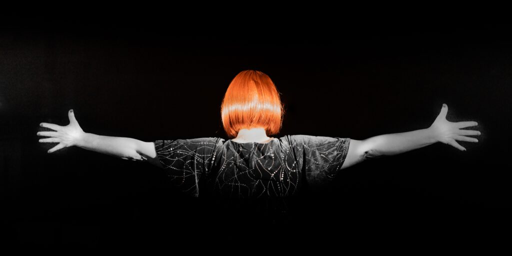 woman with a red bob haircut facing away from camera