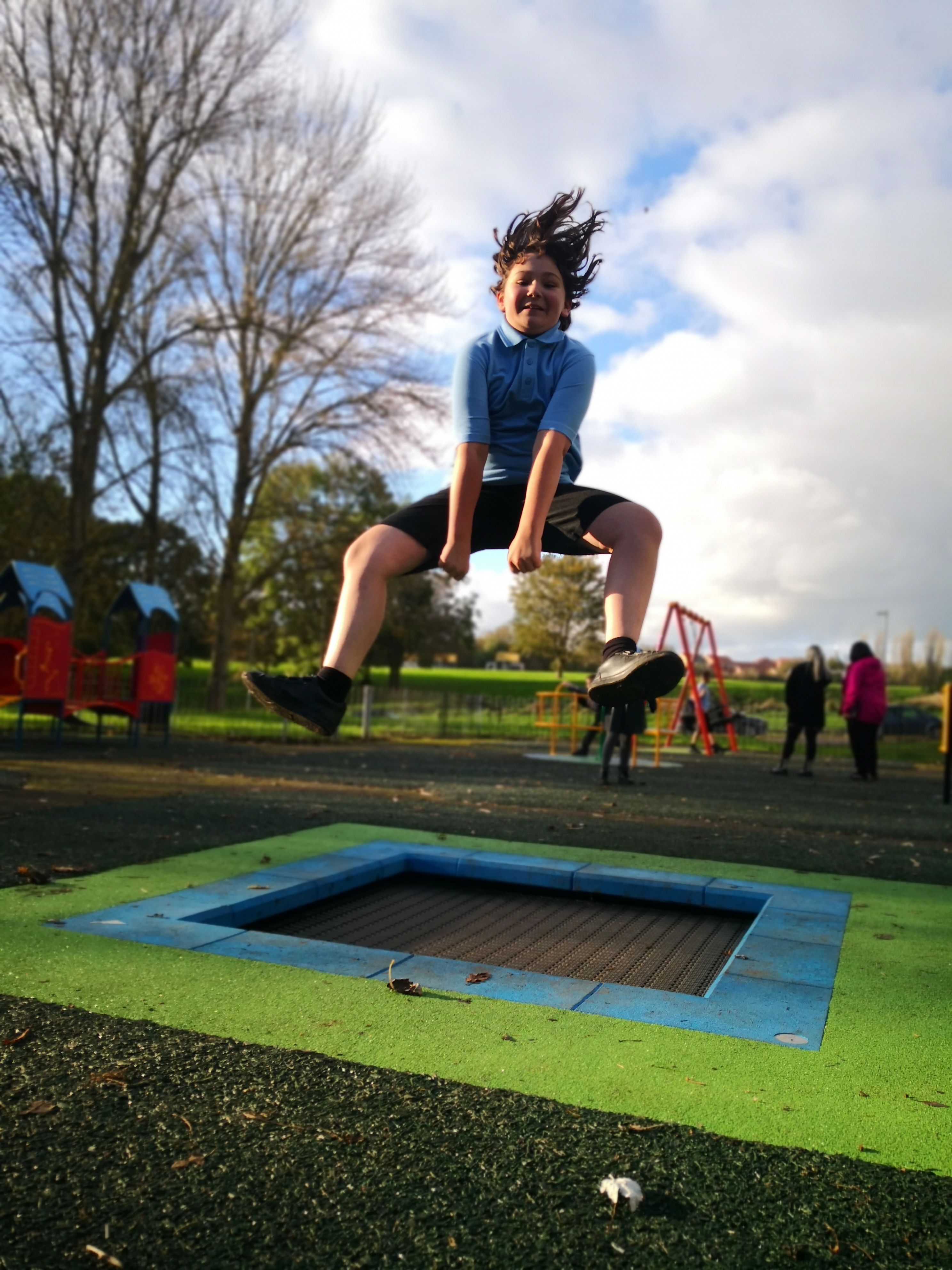 A child jumping in the air from a trampoline at Lambley Lane play area
