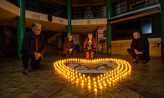 Councillors stood next to candles as part of a vigil