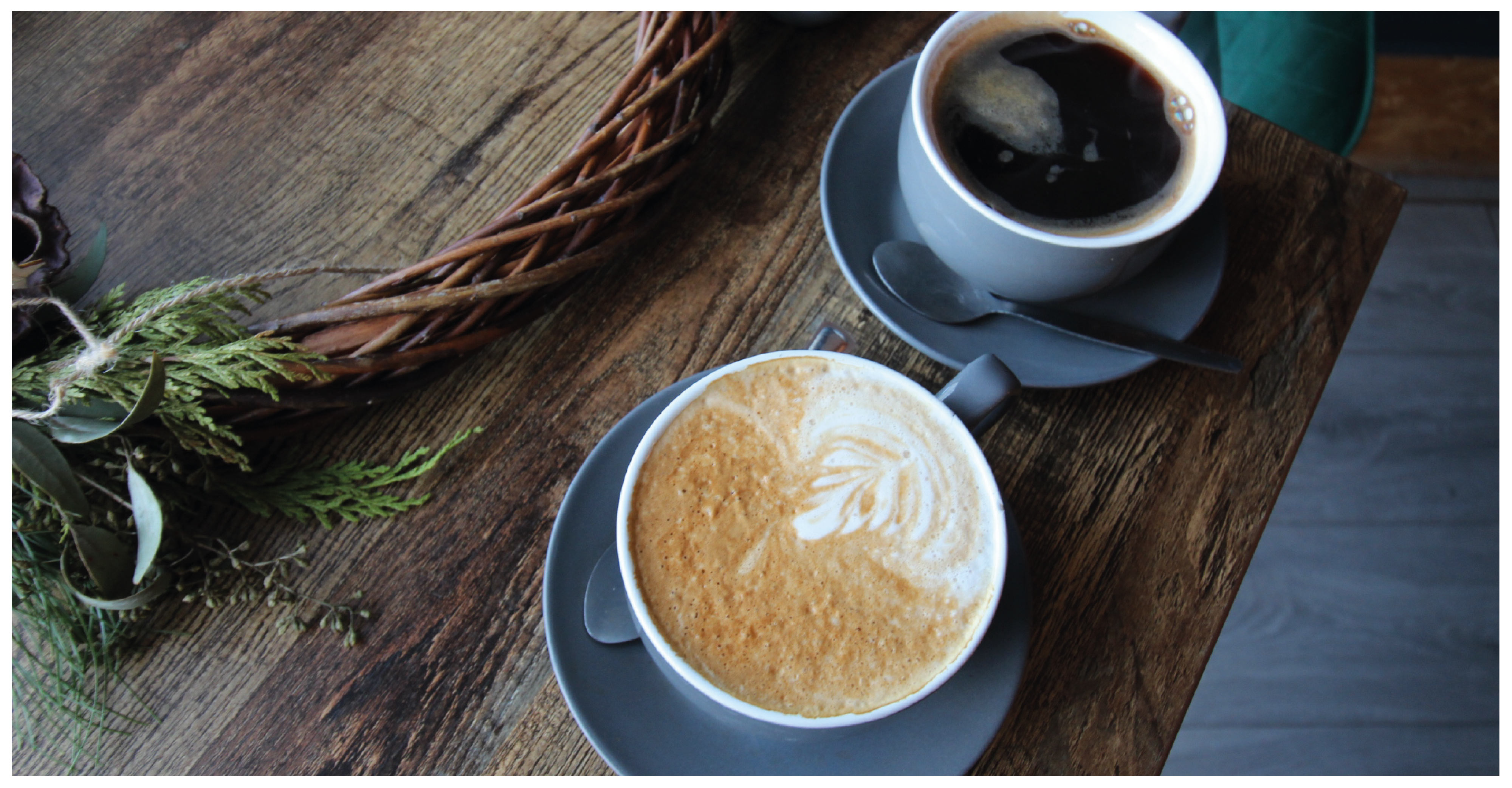 two cups of coffee on a dark wood table