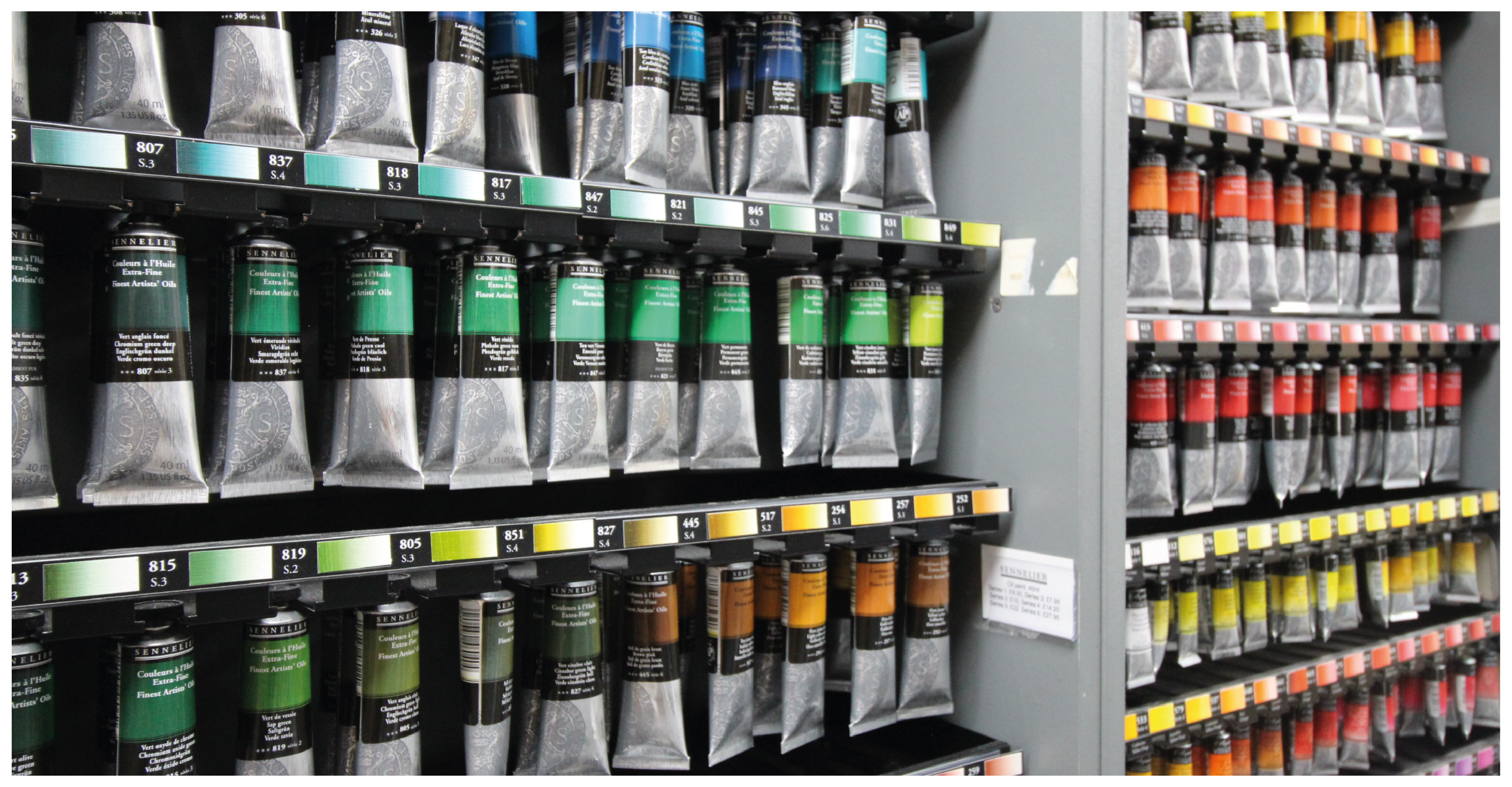 rows of colourful acrylic paints on display in a shop